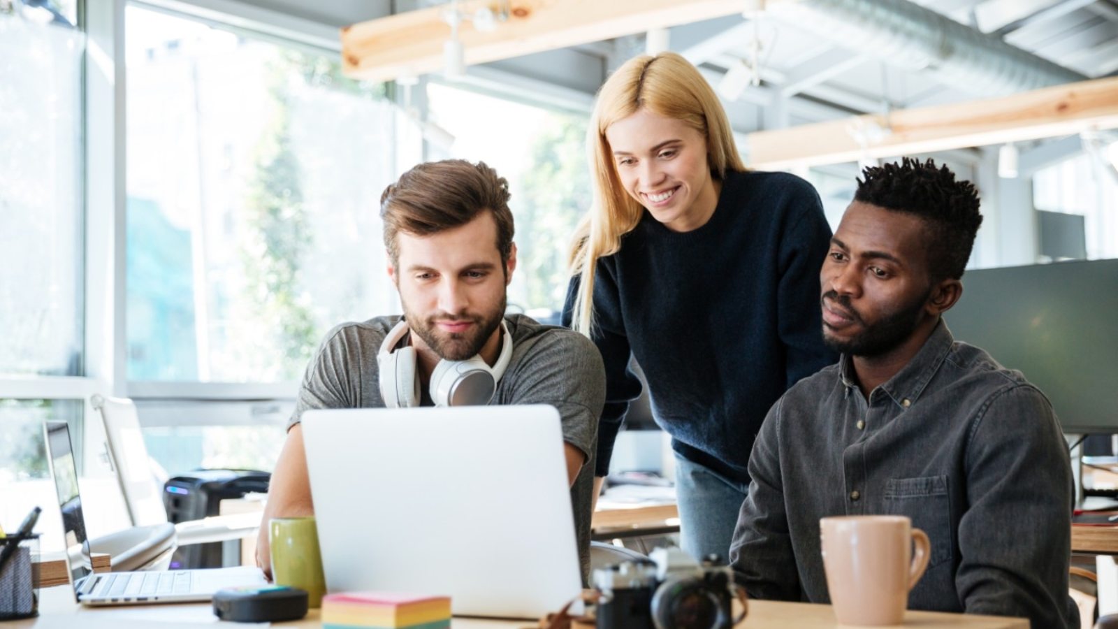 happy-colleagues-sitting-in-office-coworking-PHYA6TG