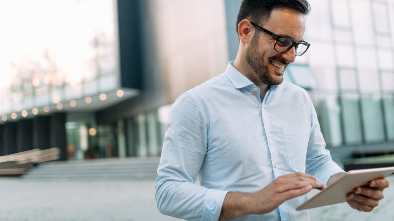 portrait-of-businessman-in-glasses-holding-tablet-AWVHCJU